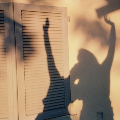 A silhouette of a person stretching against a simple background.