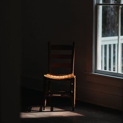 Empty yoga mat on a dark wooden floor in a calm room.